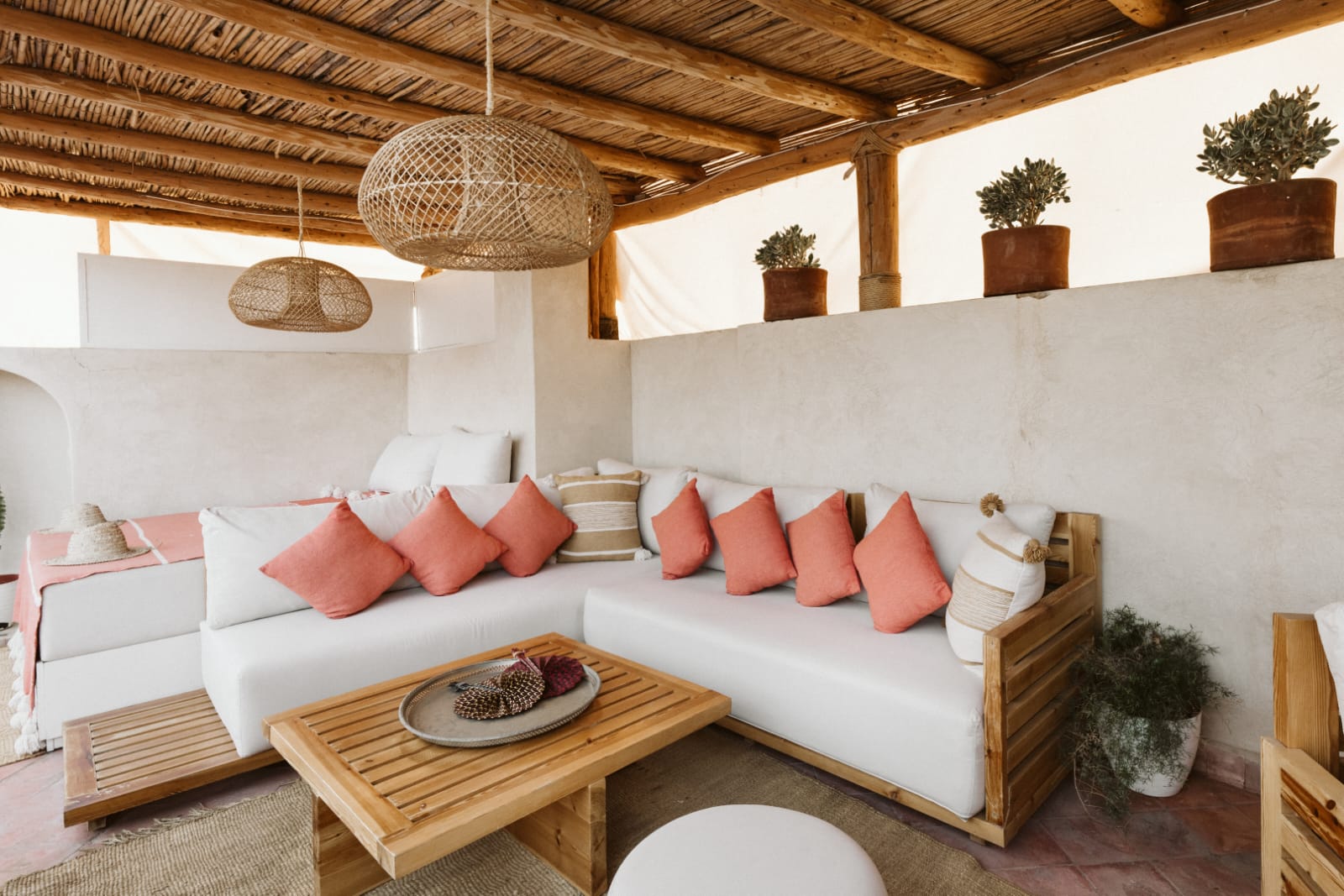 Rooftop lounge with white seating, coral cushions and bamboo ceiling at Riad Dar Alhambra Marrakech