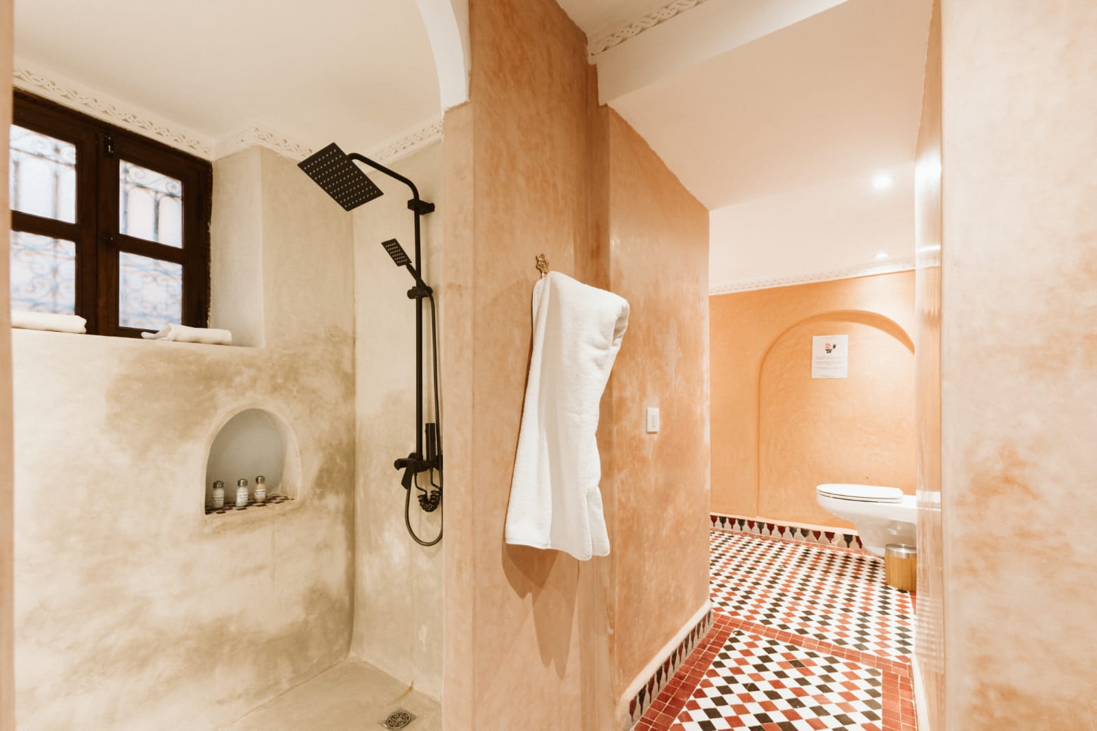 Pale tadelakt wet room with rain shower and folded towel, Riad Dar Alhambra