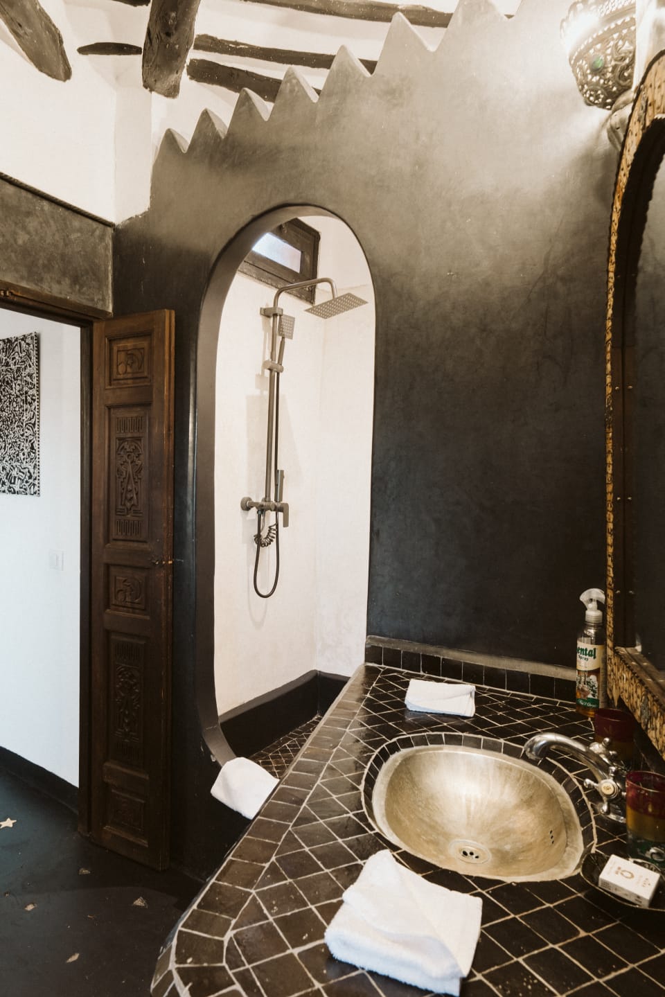 Arched alcove with a hammered brass basin and tadelakt walls at Riad Dar Alhambra, Marrakech